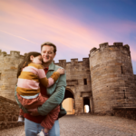 father and child standing outside castle