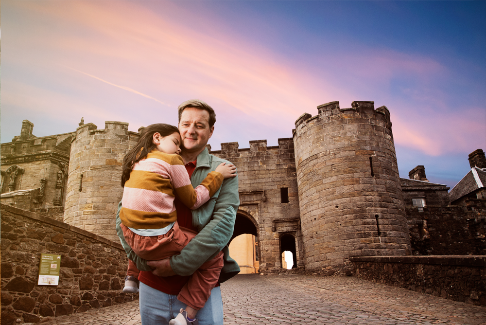 father and child standing outside castle